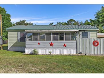 Charming home exterior with a green roof, decorative stars, and a well-maintained lawn on a sunny day at 4719 Dove Cross Dr, Lakeland, FL 33810