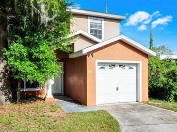 Two-story tan home with a single car garage and green lawn at 156 Oak Grove Rd, Winter Park, FL 32789