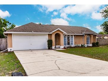 Charming single-story home with a two-car garage, well-maintained lawn, and inviting curb appeal at 206 Chris Ct, Davenport, FL 33896