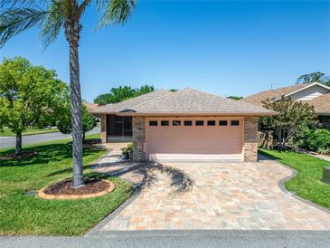 Charming home featuring a two-car garage and patterned brick driveway, surrounded by lush landscaping at 622 Jamaica Cir, Lakeland, FL 33803