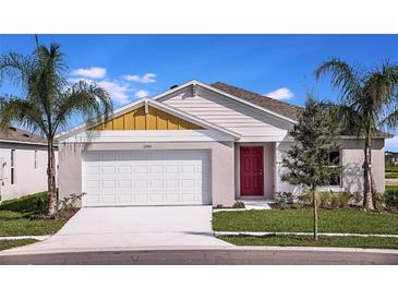 Charming single-story home featuring a red front door, a two car garage and fresh landscaping at 1034 Foreshore Ln, Haines City, FL 33844