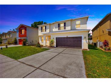 Two-story home featuring a spacious driveway, attached garage, and well-maintained lawn at 2448 Brownwood Dr, Mulberry, FL 33860