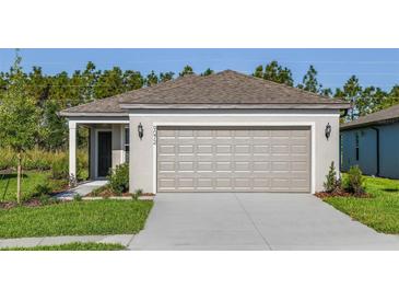 Charming single Gathering home features a neutral paint scheme, manicured lawn, and a large two car garage at 9072 Wildlight Trl, Wildwood, FL 34785