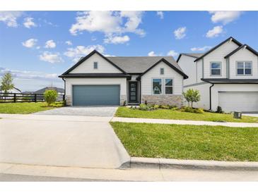 Charming single-story home with a well-manicured lawn and a gray garage door at 16998 Cedar Valley Cir, Clermont, FL 34711