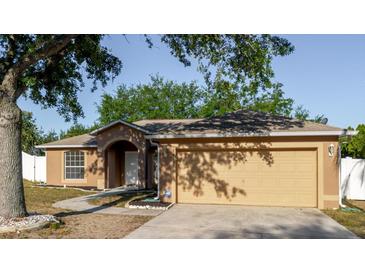 Charming single-story home with a two-car garage and manicured landscaping at 1472 Muir Cir, Clermont, FL 34711