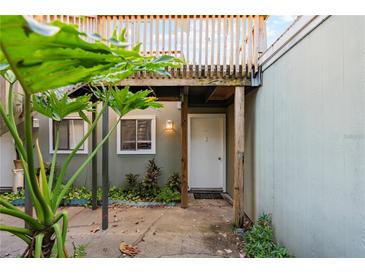 Charming entrance with a white door, lush landscaping, and a cozy, inviting appeal to this lovely home at 337 Scottsdale Sq # 337, Winter Park, FL 32792
