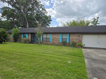 Charming single-story brick home with blue shutters, well-maintained lawn, and mature shade trees at 4506 Se 7Th Pl, Ocala, FL 34471