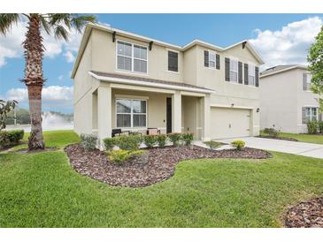 Charming two-story home with a well-manicured lawn and beautiful landscaping at 3387 Tawny Grove Pl, Lakeland, FL 33811