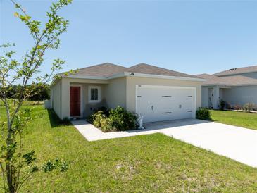 Charming single-story home featuring a manicured lawn, attached two-car garage, and a welcoming front door at 726 Eagle Landing Blvd, Winter Haven, FL 33880