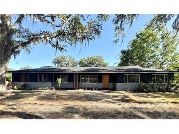 Charming single-story home featuring an inviting front yard with mature trees and a well-maintained exterior at 3465 Peacock Ln, Mulberry, FL 33860