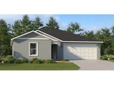 Charming single-story home featuring a well-manicured lawn, gray siding, and an attached two-car garage at 1626 Teagan Ln, Winter Haven, FL 33884