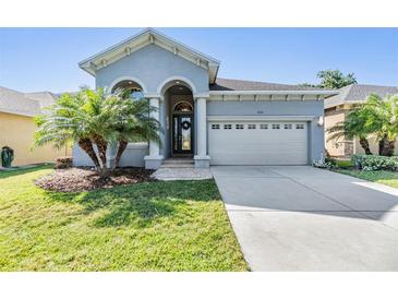 Charming one-story home featuring a two-car garage and a well-manicured front yard with lush green grass at 1035 Stoney Creek Dr, Lakeland, FL 33811