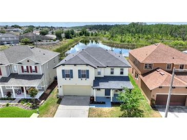 Beautiful two-story home featuring a front-entry two-car garage and scenic backyard pond view at 634 Canna Dr, Davenport, FL 33897