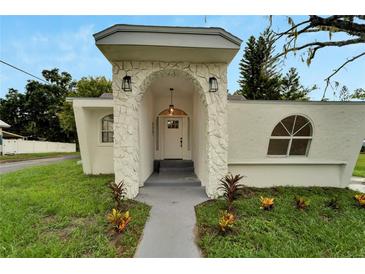 Inviting front entrance with stone archway, modern lighting, and well-maintained landscaping enhances curb appeal at 800 N Church Ave, Mulberry, FL 33860