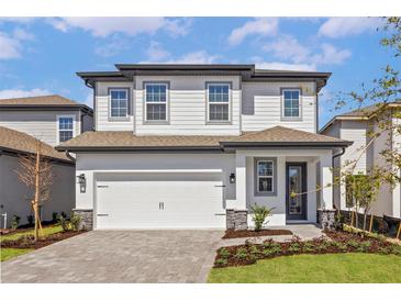 Charming two-story home with a two-car garage and beautifully landscaped front yard at 7732 Somersworth Dr, Kissimmee, FL 34747