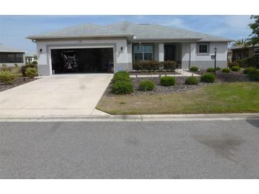 Charming single-story home with a well-manicured front yard and an open garage at 8890 Sw 104Th Cir, Ocala, FL 34481