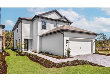 Stunning two-story home with a meticulously maintained lawn, paved walkway, and an attached two-car garage at 7692 Somersworth Dr, Kissimmee, FL 34747
