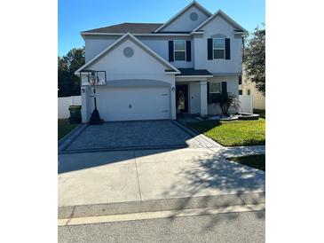 Charming two-story home with a paver driveway and basketball hoop at 2121 Amor Way, Leesburg, FL 34748