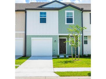 Charming townhome featuring a one car garage, and green lawn at 3273 Vesara Dr, Davenport, FL 33837