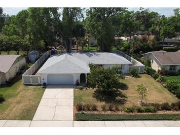 Charming single-story home with mature trees, well-maintained landscaping, and a fenced backyard at 3446 Country Manor Dr, Port Orange, FL 32129