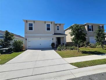 Charming two-story home featuring a two-car garage and well-manicured front yard at 1204 Berry Ln, Davenport, FL 33837