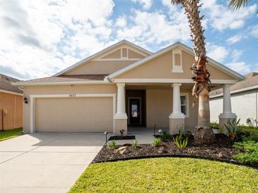 Charming single-story home with a two-car garage, manicured lawn, and a welcoming front porch with elegant columns at 2457 Torrens Dr, Lakeland, FL 33805