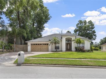 Charming single-story home with a well-manicured lawn, arched entry, and a two-car garage at 2170 Lake Marion Dr, Apopka, FL 32712