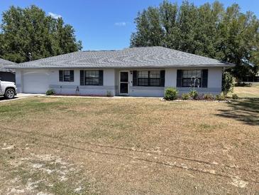 Charming single-story home featuring a well-maintained lawn and neutral exterior at 11757 Se 71St Terrace Rd, Belleview, FL 34420