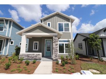 Charming two-story home with gray siding, stone accents, and a well-manicured front yard at 3098 Voyager Ave, St Cloud, FL 34771