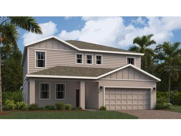 Two-story home boasts a neutral color palette, manicured lawn, two-car garage, and tropical landscaping at 1967 Rider Rain Ln, Apopka, FL 32703