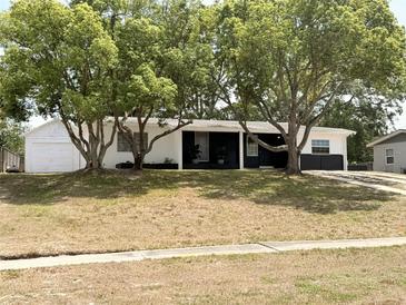 Charming single-story home with mature trees, freshly painted in white and black trim at 1505 Piedmont Dr, Deltona, FL 32725