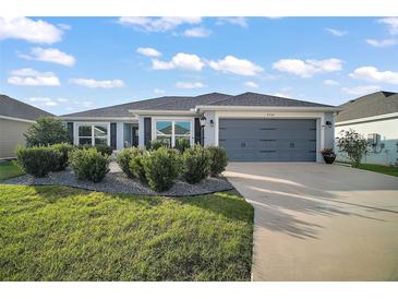 Charming home with landscaped front yard, two-car garage, and well-maintained lawn at 5754 Shealy Ave, The Villages, FL 32163