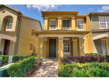 Charming two-story townhome featuring a covered entryway and neatly landscaped front yard at 7752 Moser Ave, Windermere, FL 34786