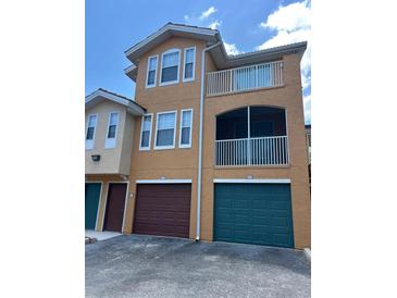 A three-story condo features private balconies and garage doors with unique colors at 12020 Villanova Dr # 107, Orlando, FL 32837