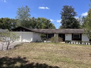 Charming single-story home featuring a two-car garage and mature landscaping in a suburban setting at 1230 Jasmine Rd, Apopka, FL 32703