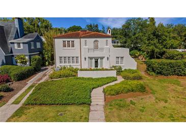 Charming two-story home featuring a terracotta roof, front balcony, manicured yard, and lush landscaping at 2417 Coventry Ave, Lakeland, FL 33803