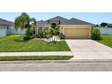 Well-maintained home featuring a manicured lawn and tropical landscaping at 4662 Harts Brook Ln, Mulberry, FL 33860