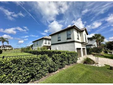 Charming two-story home with a well-manicured lawn and lush greenery, perfect for curb appeal at 1056 Castle Pines Ct, Reunion, FL 34747
