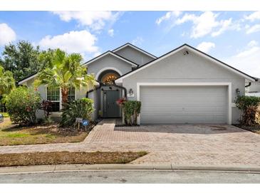 Charming single-Gathering home with a well-manicured lawn, mature landscaping, and a two-car garage on a sunny day at 547 Windsor Pl, Davenport, FL 33896
