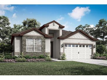Charming single-story home featuring stone accents, a two-car garage, and manicured landscaping at 3331 Chinotto Dr, Lake Alfred, FL 33850