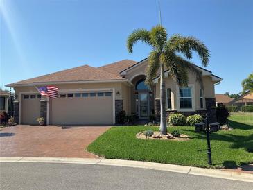 Charming home with a well-maintained lawn, landscaping, and a two-car garage, complete with an American flag at 1415 Colonial Ct, Winter Haven, FL 33884