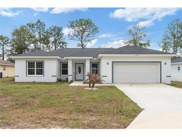 Charming single-story home features a welcoming front yard, attached garage, and newly painted exterior at 14404 Sw 19Th Pl, Ocala, FL 34481