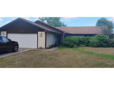 Charming single-story home featuring an attached garage and well-maintained landscaping at 9873 County Road 114B, Wildwood, FL 34785