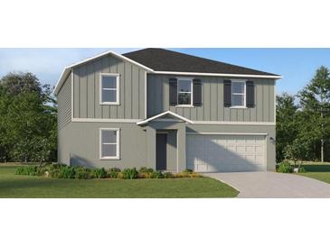 Two-story home with gray siding, black shutters, and a two-car garage is surrounded by a green lawn at 2751 Pioneer Trl, Eagle Lake, FL 33839