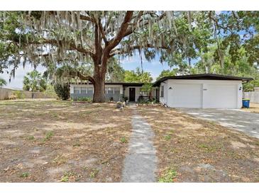 Charming single-story home with attached garage and a large oak tree in the front yard at 1895 Emerson Ave, Bartow, FL 33830