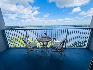 Balcony view with table and chairs overlooking the water at 13415 Blue Heron Beach Dr # 1006, Orlando, FL 32821