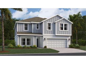 Charming two-story home featuring a light gray exterior, well-manicured lawn and attached two car garage at 463 Puma Loop, Groveland, FL 34736