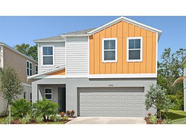 Two-story home featuring a two-car garage, and landscaping in front of the home at 1756 Frogmore Ave, Haines City, FL 33844