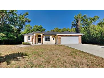 Charming single-story home featuring brick accents, attached two-car garage, and a well-maintained lawn at 210 Alta Vista St, Debary, FL 32713