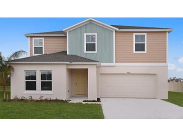 Inviting two-story home featuring a two-car garage, well-maintained lawn, and a charming light yellow front door at 1046 Foreshore Ln, Haines City, FL 33844